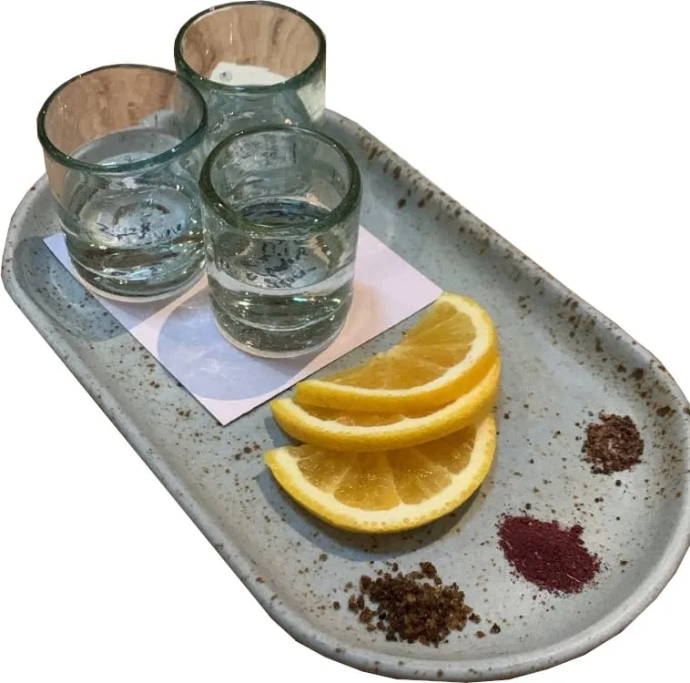 Dégustation de mezcal : trois verres avec quartiers d’orange et sel de ver, comme celles proposées par la mezcalería Salón Mezcalli (photo d’illustration)