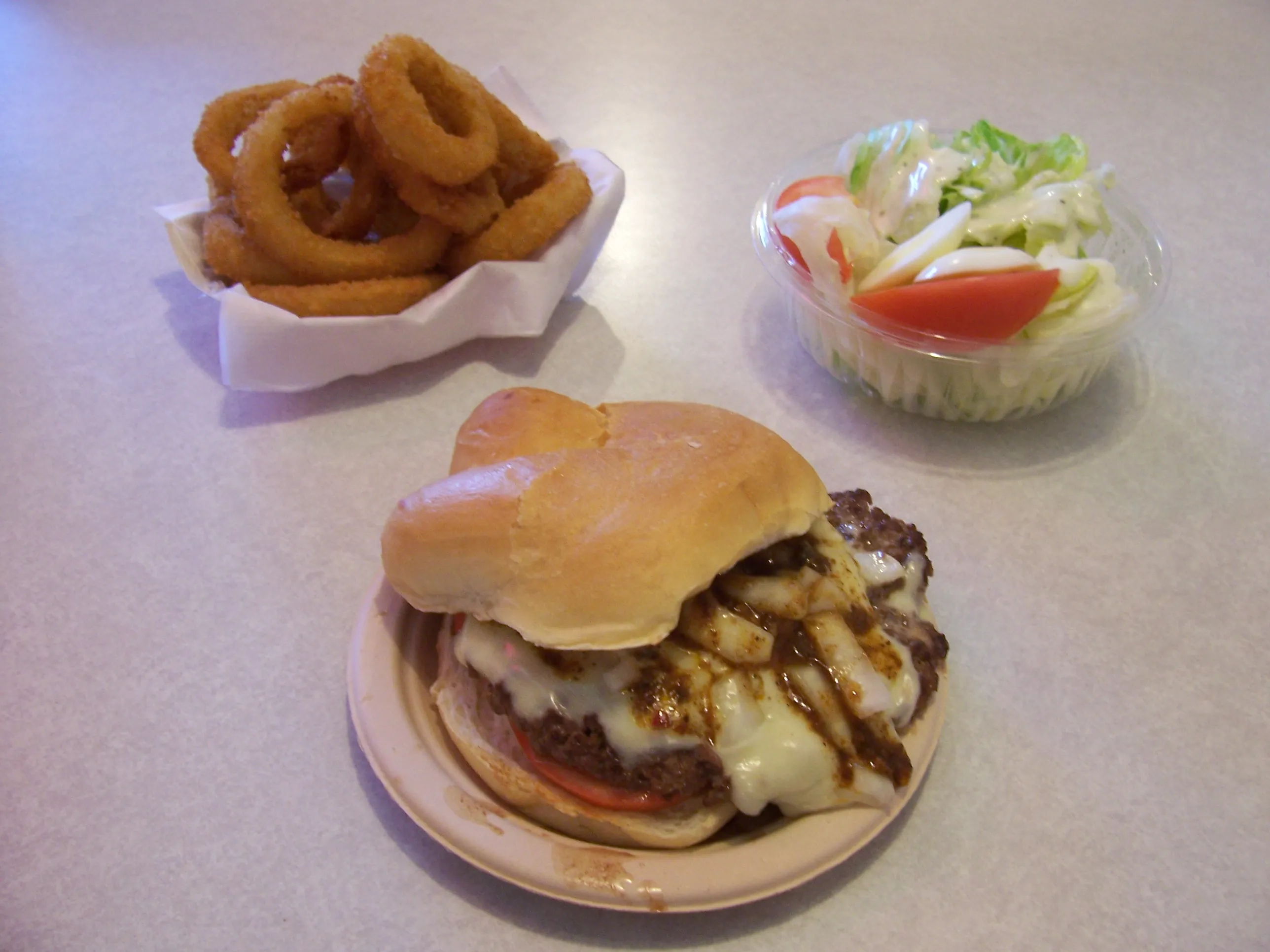 Ground steak sandwich de Tom Wahl’s au fromage fondu avec rondelles d’oignon, alternative locale à Five Guys à Rochester