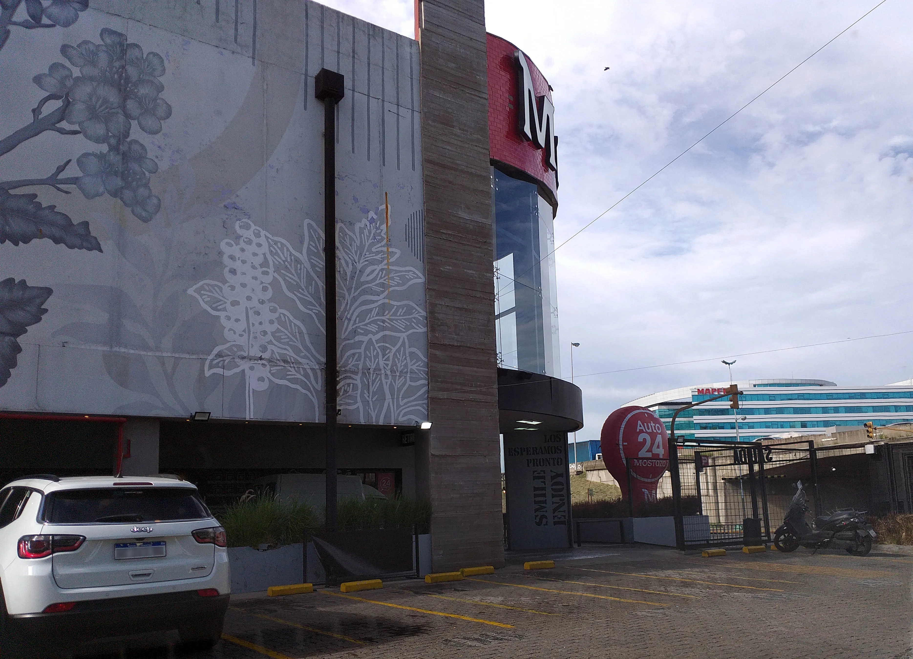 Parking signage at a large standalone Mostaza restaurant, a drive-thru format like the AutoMostaza in Salta